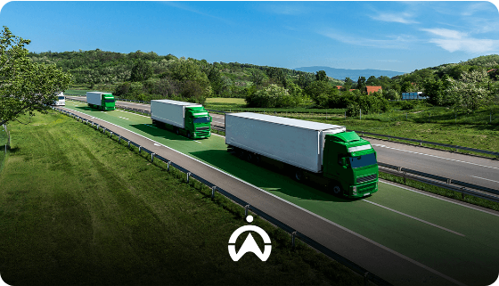 Tre camion con rimorchio bianco e motrice verde su un'autostrada tra le colline.